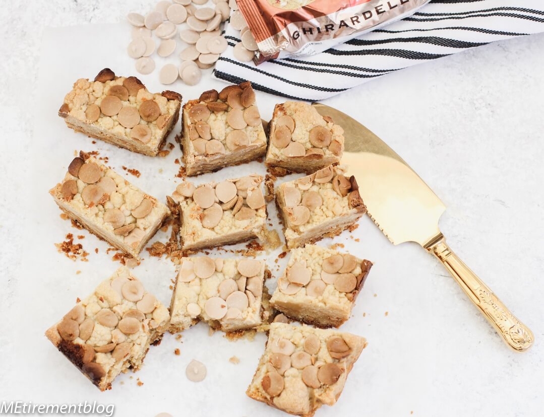 Caramel White Chocolate Blondies on marble slab with gold cake server