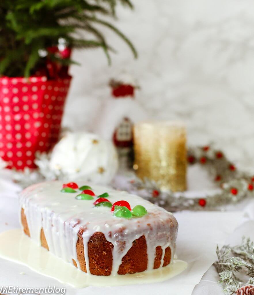 Cream Cheese Fruitcake large loaf covered in white chocolate icing with dried red and green cherries on top