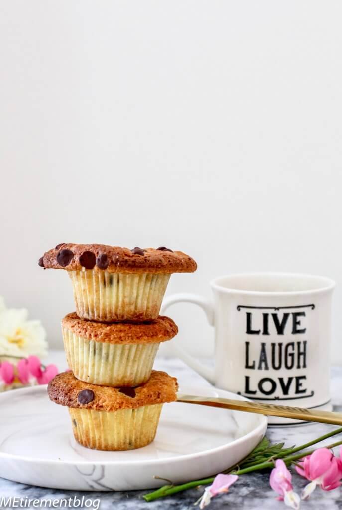 Crispy Top Orange Chocolate Muffins stacked on plate with coffee mug