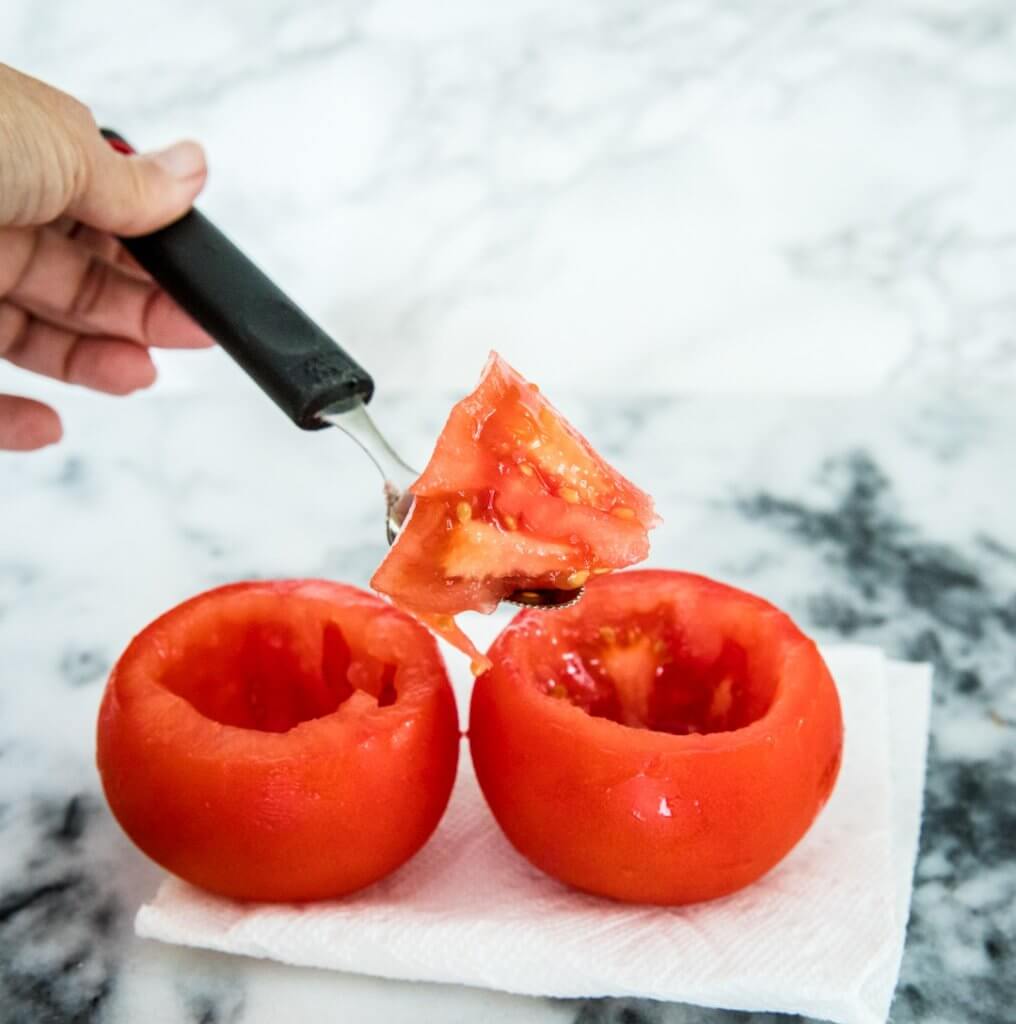 scooping out tomatoes with a grapefruit spoon