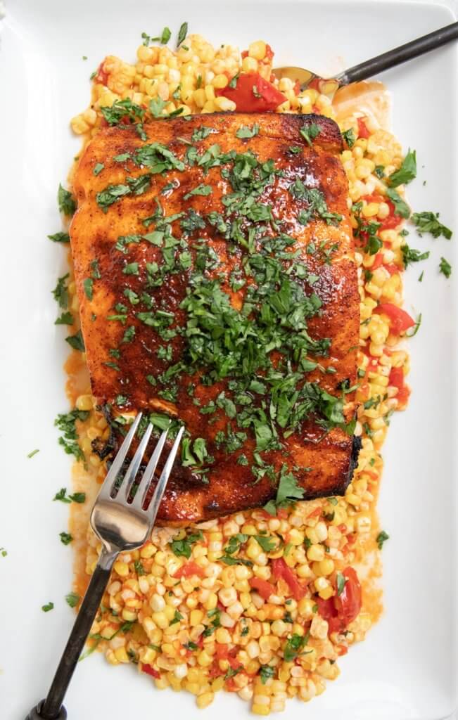Grilled Glazed Salmon with Tomato Corn Saute on white plate with silver fork