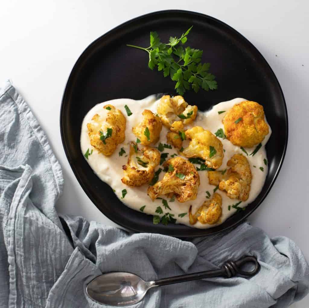 Roasted Cauliflower with Moroccan Spices and Curried Yogurt with garnish